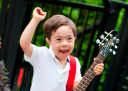 Criança com síndrome de Down tocando guitarra
