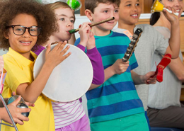 Crianças tocando percussão e flauta